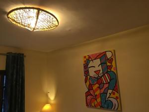 a painting of a cat on a wall next to a light at CostaSol Pipa Chalés in Pipa