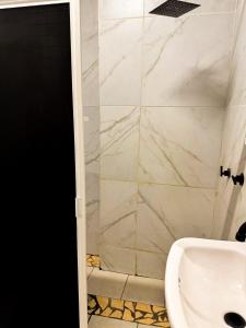 Luxury en el Centro de GDL في غواذالاخارا: حمام مع حوض غسيل أبيض ودش