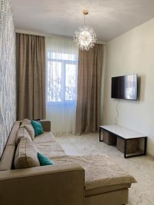 ein Wohnzimmer mit Sofa und Flachbildfernseher in der Unterkunft S-Van Cozy Home in Sewan