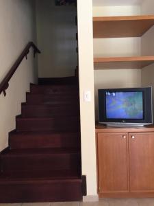 a staircase with a flat screen tv and a tv stand at CostaSol Pipa Chalés in Pipa