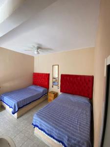 2 łóżka w sypialni z czerwoną i niebieską pościelą w obiekcie Casa de los Abuelos w mieście Itzamatitlán +14 zdjęć