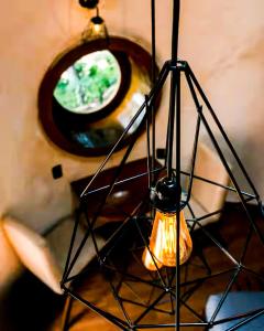 a lamp with a mirror and a light on a table at Domo Abitare Glamping in Isla de Mezcala