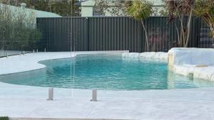 a swimming pool with an ice rink in a backyard at Palacete Beach Resort - entire home in Culburra Beach