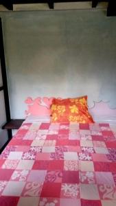 波拉波拉Chez Hina no Pacifica的一间卧室配有一张带粉色和白色被子的床