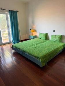 a bedroom with a bed with a green comforter at Murdeira Villa with Private Pool V164 by RPG Group in Beirona +44 photos