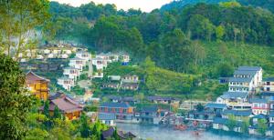 Ban Rak Thaiม่านหมอก รักไทย ManMork RakThai的河边小山上的一群房子