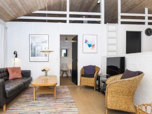 a living room with a couch and a tv at 12 person holiday home in Fanø-By Traum in Fanø