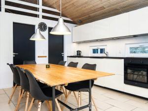 a kitchen and dining room with a wooden table and chairs at 12 person holiday home in Fanø-By Traum in Fanø