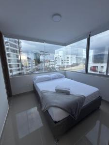Un dormitorio con una cama grande frente a una ventana. en hotel portal del cerro manizalez, en Manizales 24 fotos más