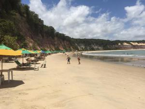 a group of people walking on the beach at CostaSol Pipa Chalés in Pipa