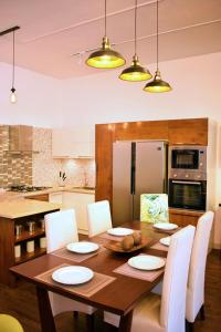 a kitchen with a wooden table with white chairs at Penthouse Bandarawela in Bandarawela +24 photos