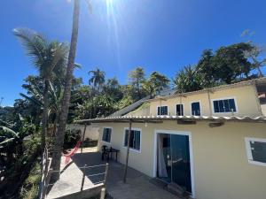 vista su una casa con una palma di Suítes Beira-Mar Angra dos Reis ad Angra dos Reis