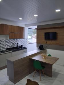 a kitchen with a wooden table and a green chair at Apartamento moderno próximo ao centro in União da Vitória