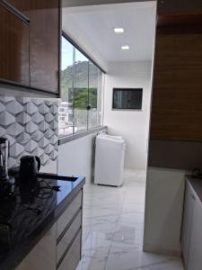 a kitchen with a white refrigerator and a window at Apartamento moderno próximo ao centro in União da Vitória