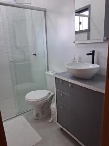 a bathroom with a toilet and a sink and a shower at Apartamento moderno próximo ao centro in União da Vitória