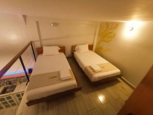 a small room with two beds and a staircase at Mi Quinta Raíz Loft Apartments in Iquitos +27 photos