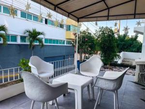un gruppo di sedie e tavoli bianchi su un patio di Villa Centenario a Mazatlán