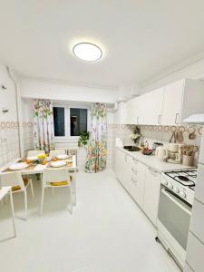 uma cozinha branca com uma mesa e uma sala de jantar em Spa Apartment With Sauna 3 Bedrooms Center Bucharest em Bucareste