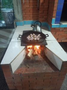 een grill met een pan met eten en een ketel erop bij Sitio Daniela in São João Batista