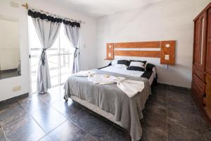 Palmeras Departamentos في سانتا تيريسيتا: غرفة نوم بها سرير ونافذة كبيرة +75 صورة