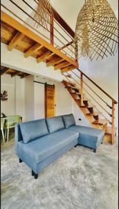 a blue couch in a living room with a staircase at Villa Isleñas - Solar, Starlink, Pool in General Luna