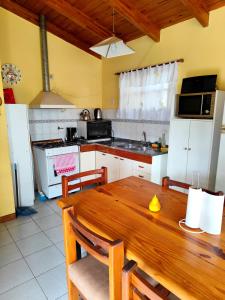 een keuken met een houten tafel en een keuken met witte apparatuur bij La Rufina chalet serrano in Río Ceballos