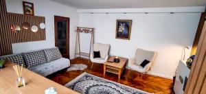 a living room with a couch and two chairs at Magic Craiova Stay in Craiova