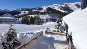 Un patio cubierto de nieve con una montaña al fondo. en Chalet Katschberg Panorama, en Katschberghöhe