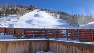 una valla de madera con nieve en una pista de esquí en Chalet Katschberg Panorama, en Katschberghöhe