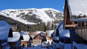 una ciudad con techos nevados y una montaña en Chalet Katschberg Panorama, en Katschberghöhe
