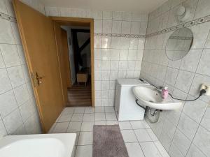 un bagno con lavandino, WC e specchio di Ferienwohnung und Monteurzimmer Nähe Leuna, Merseburg, Halle und Leipzig a Braunsbedra 1 altra foto
