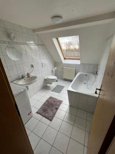 un bagno con vasca, WC e lavandino di Ferienwohnung und Monteurzimmer Nähe Leuna, Merseburg, Halle und Leipzig a Braunsbedra