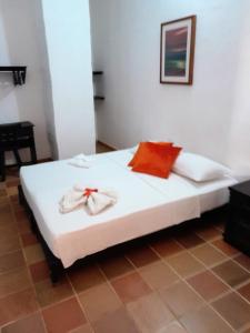 Una cama blanca con dos toallas encima. en Hospedaje Don Juan, en Barichara