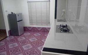 Una cocina con encimera blanca y refrigerador. en Serenity House khlongnin, en Phra Ae beach