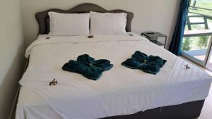 un letto con tre cuscini blu sopra di Greenview Room and Restaurant 