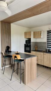a kitchen with a table and some chairs in it at MAJO LOUNGE dans un jardin tropical à 5 min de la mer Caraïbe in Saint-Pierre