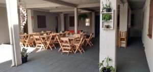 a restaurant with wooden tables and chairs in a room at Pousada maré torres in Torres