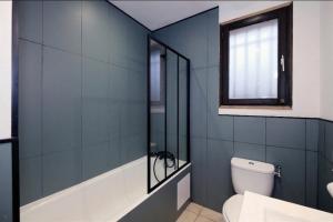 Un baño con bañera, inodoro y ventana. en Welcome Home, en Vert-le-Grand 56 fotos más