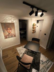 a living room with a table and chairs and a painting at Pri Home in Pristina