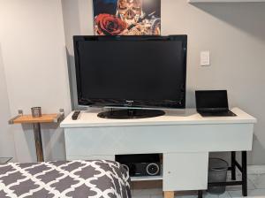 a computer monitor on a white desk in a room at Chic Japanese Vibe Smart Home- Liberty Village 10 min walk to CNE & GO Station in Toronto +4 photos