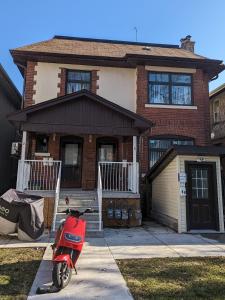 a red scooter parked in front of a house at Chic Japanese Vibe Smart Home- Liberty Village 10 min walk to CNE & GO Station in Toronto