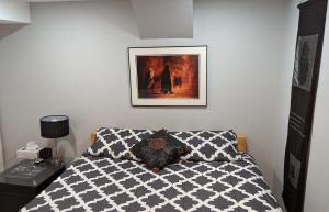 a bedroom with a bed and a picture on the wall at Chic Japanese Vibe Smart Home- Liberty Village 10 min walk to CNE & GO Station in Toronto