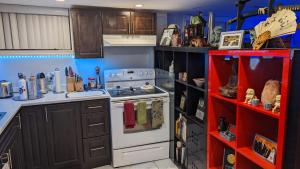 a kitchen with a white stove and a red shelf at Chic Japanese Vibe Smart Home- Liberty Village 10 min walk to CNE & GO Station in Toronto