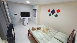 una camera da letto con un letto con un arco sopra di Suíte península de Búzios a Búzios