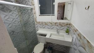un bagno con lavandino, WC e specchio di Suíte península de Búzios a Búzios