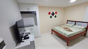 una camera da letto con un letto e una TV a schermo piatto di Suíte península de Búzios a Búzios