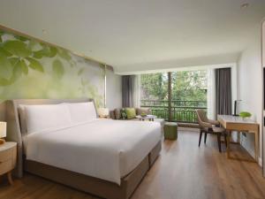 a bedroom with a large bed and a living room at Mövenpick BDMS Wellness Resort Bangkok in Bangkok +228 photos