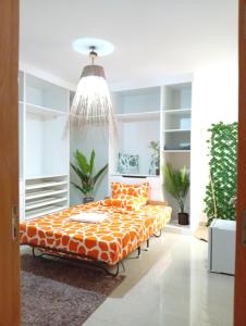 普拉亚Four Palms Boutique Hotel的客厅里有一张橙色的床和一个吊灯。