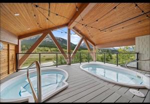 a large room with a hot tub on a deck at Luxury 2 Bedroom Mountain View Condo in Canmore