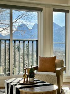 a living room with a couch and a large window at Luxury 2 Bedroom Mountain View Condo in Canmore